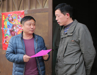 2月15日,新城街道恩村一街村委会工作人员(左)在为征迁户讲解征迁